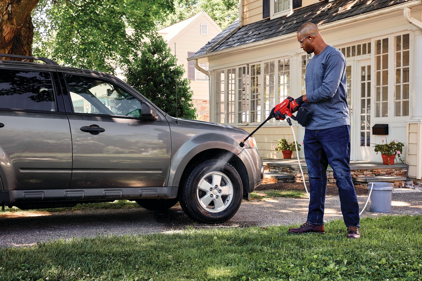 20 volt cordless 350 max P S I power cleaner being used by a person to clean car tyre outdoors.