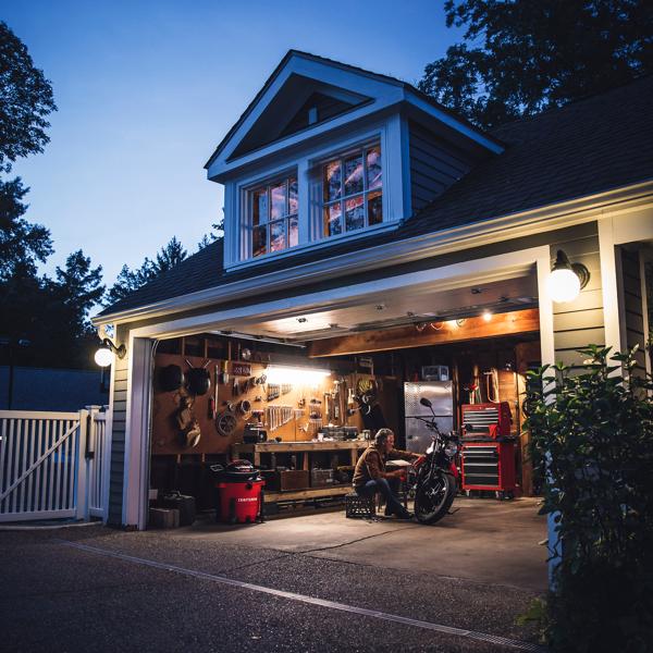 Mechanic working on motorcycle in garage with CRAFTSMAN vacuum stored neatly by CRAFTSMAN tools