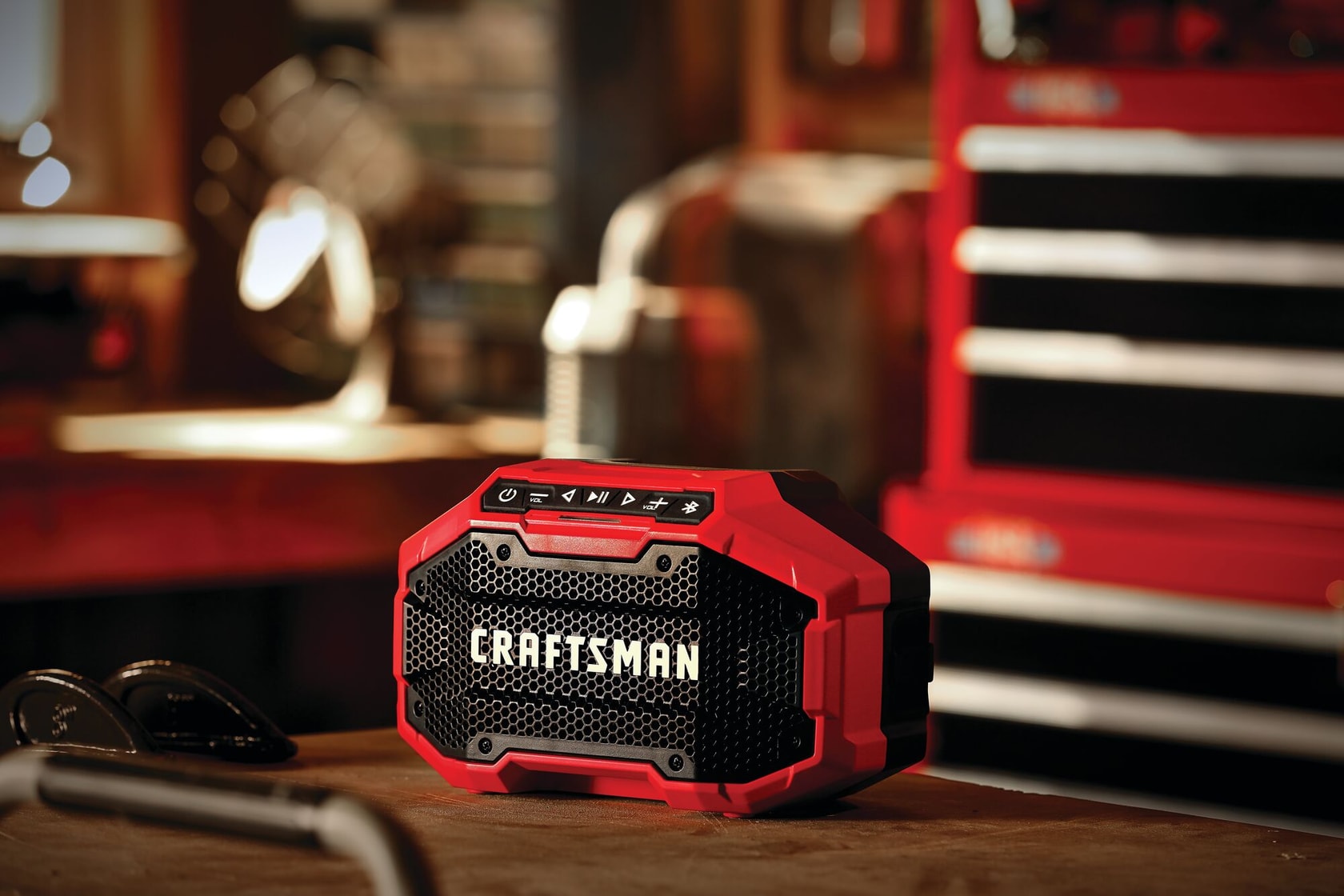 20 volt cordless bluetooth speaker placed on a wooden work station in a work shop.