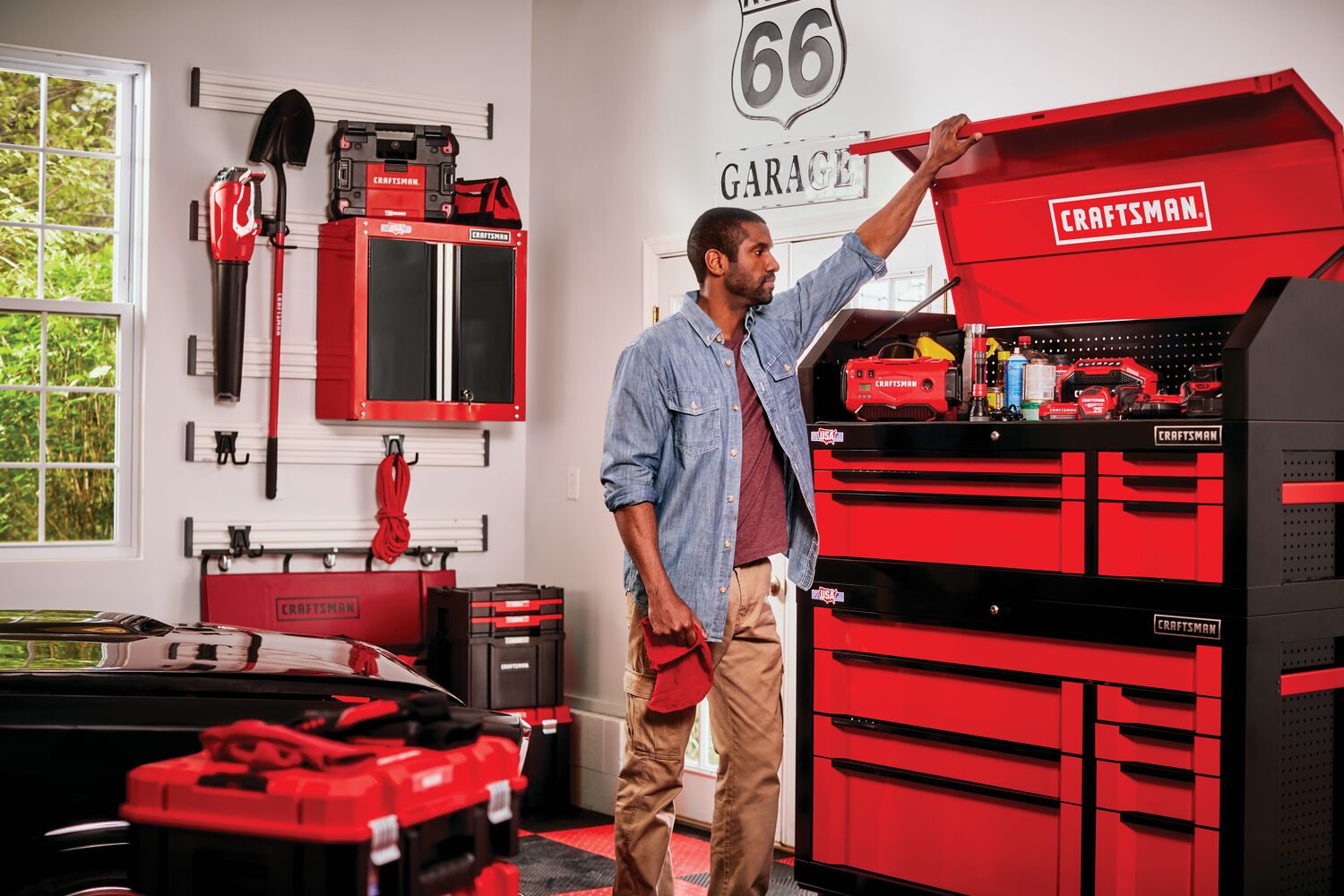 Tool cabinet along with other tools mounted on Versa Track 5 and 5 tenths inch White Composite Multipurpose Storage Rail System installed on wall of a garage workshop while person opens up a tool chest.