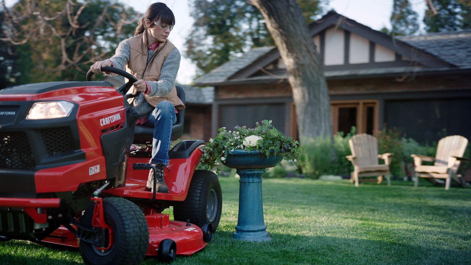 46 inch 22 h p hydrostatic riding mower with turn tight being used by a person to mow the lawn beside a fountain.